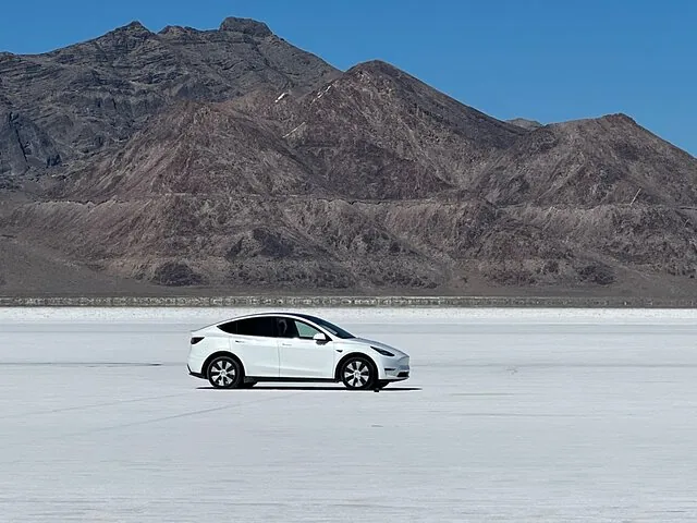 Weißes Auto auf den Bonneville Salt Flats mit Bergen im Hintergrund